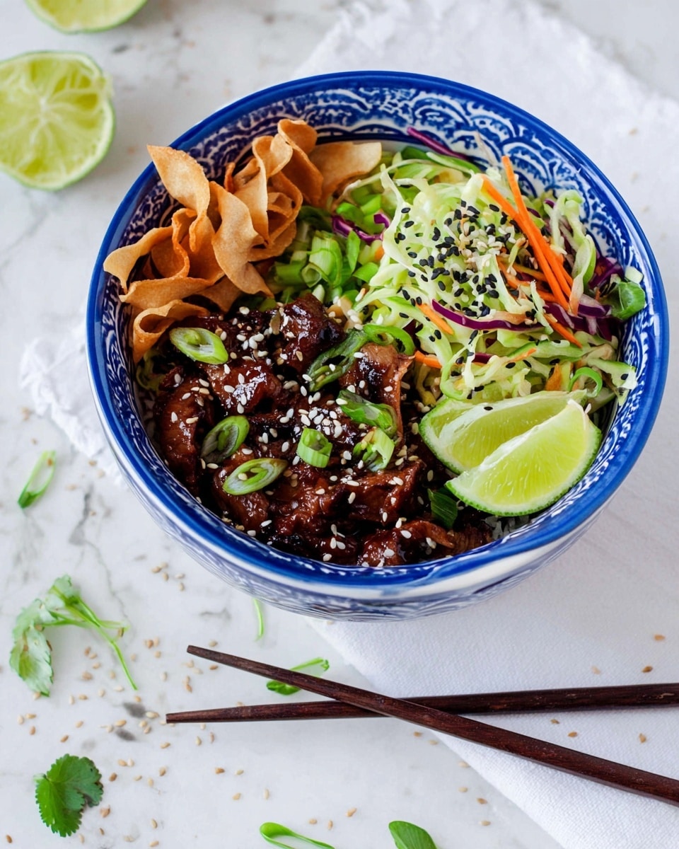 The image shows a blue and white patterned bowl filled with a layered dish on a white marbled surface. The bottom layer is a fresh mix of thinly sliced green vegetables, including cabbage and carrots, with some purple strands, placed on one side of the bowl. Next to it, there are two bright green lime wedges. On the opposite side, there are several crispy beige strips, which add texture. On top of the vegetables, in the center, there are dark brown glazed pieces of meat sprinkled with white and black sesame seeds, giving a shiny and textured appearance. A pair of dark brown chopsticks lie near the bowl and some green herbs and sesame seeds are scattered on the surface nearby. Photo taken with an iphone --ar 4:5 --v 7