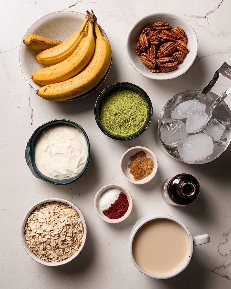 The image shows a variety of baking ingredients placed on a white marbled surface. On the left, a white bowl contains peeled and whole yellow bananas. Above it, a small white bowl holds brown pecans. In the center, a tiny black bowl filled with bright green powder (matcha) sits next to a metal measuring cup filled with white cream. Below, a small white bowl is filled with light brown rolled oats. Near the bottom, a small black bowl contains two piles of spices, one red and one white. To the right, a transparent scoop holds a brown powder, and next to it is a small dark bottle of vanilla extract. On the far right side, there is a white cup of light beige liquid, and part of a white enamel bowl filled with ice cubes is visible. The photo taken with an iphone --ar 4:5 --v 7
