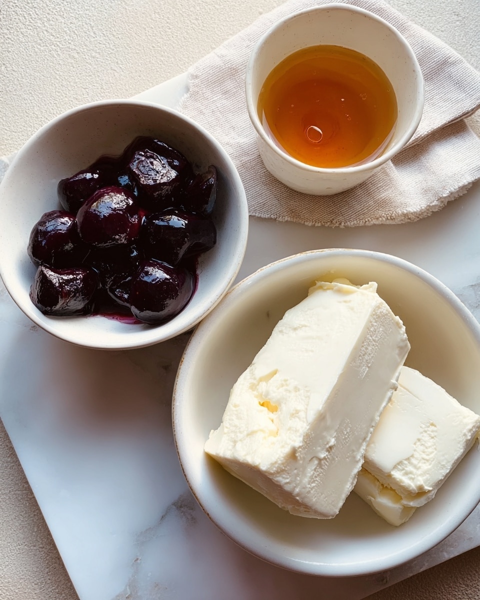 The image shows three bowls on a white marbled surface. The largest bowl on the right is white and filled with two thick, uneven blocks of creamy white butter with a soft, slightly crumbly texture. To its left is a medium white bowl containing dark purple, glossy cherry halves in syrup, with a shiny liquid pooling around them. Above these two bowls, there is a small cup with a golden amber liquid, possibly honey, reflecting light. The scene has a soft natural light coming from the left side. Photo taken with an iphone --ar 4:5 --v 7