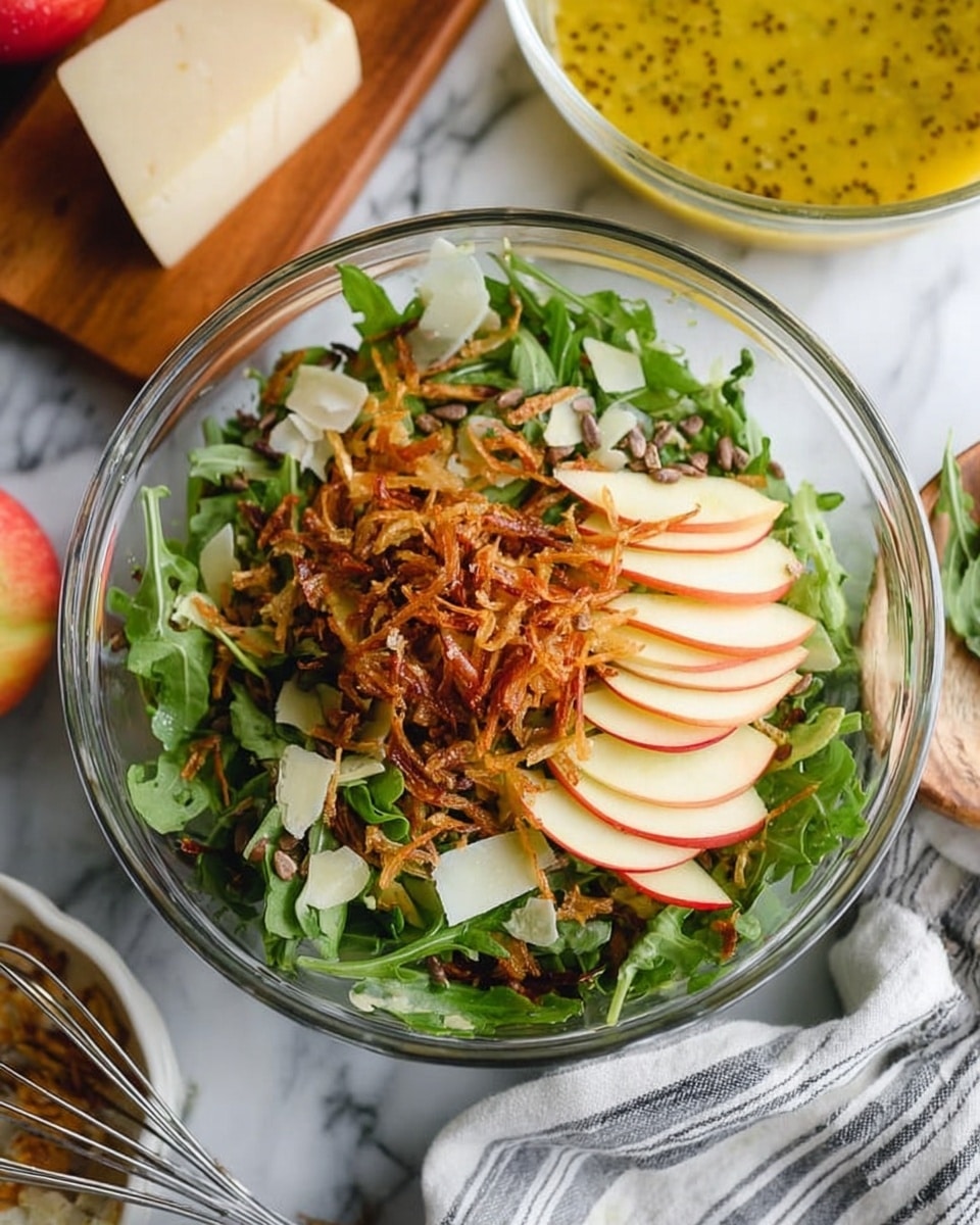 This close-up image shows a quinoa salad with several layers mixed together. The base layer is fluffy, light beige quinoa with a grainy texture. Scattered throughout are thin slices of red-skinned apple with white flesh, giving a fresh, crisp look. Green arugula leaves add a touch of vibrant color and texture. There are small, dark green pumpkin seeds sprinkled among the layers. Light brown, crispy fried shallots are spread over the top, adding a crunchy layer. Thin white shavings of cheese are strewn unevenly on the surface, contrasting with the colorful ingredients. The salad is presented on a white plate placed on a white marbled surface. Photo taken with an iphone --ar 4:5 --v 7