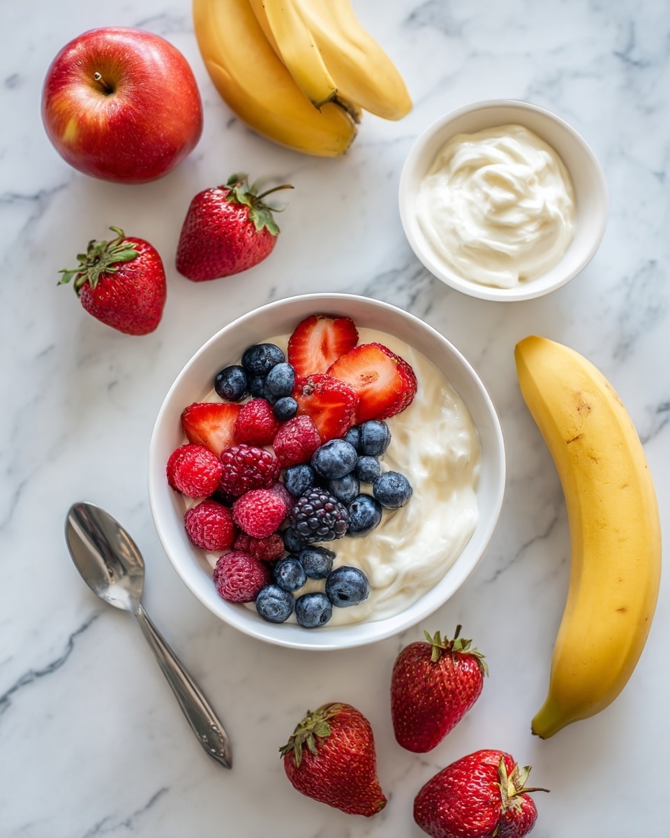 A white bowl filled with layers of vibrant fruits and yogurt sits on a white marbled surface. The bottom layer is creamy white yogurt with a smooth texture. On top, there is a layer of colorful fresh berries, including blueberries, sliced strawberries, and raspberries, creating a mix of deep blues, red, and pink. Around the bowl, whole strawberries, blueberries, three whole red apples, and two ripe yellow bananas are arranged casually. A small white bowl filled with creamy white yogurt and a silver spoon is placed nearby. The scene is bright and fresh, with natural light highlighting the colors and textures photo taken with an iphone --ar 4:5 --v 7