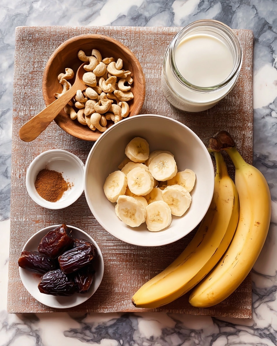 The image shows an overhead view of ingredients arranged on a white marbled surface. In the center is a white bowl containing one layer of light yellow banana slices with soft, smooth texture. To the right are two whole yellow bananas with brown tips. Below the bowl is a small white dish holding several dark brown dates with shiny wrinkled skin. To the left of the bowl is a wooden tray holding a round wooden bowl filled with light beige cashew nuts, rough and varied in shape. Above the tray is a glass jar filled with white milk. Above the bowl of banana slices is a small white bowl with light brown cinnamon powder and a small wooden spoon inside. Below the wooden tray is another small white dish with more cinnamon powder spread in a circle. Everything is carefully placed on the white marbled surface, lit softly. photo taken with an iphone --ar 4:5 --v 7