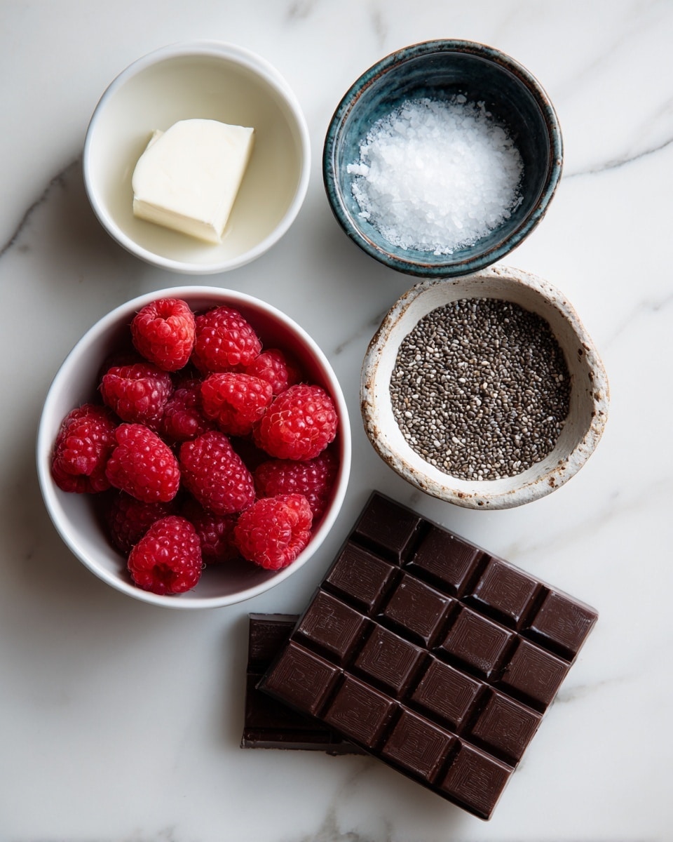 The image shows five ingredients arranged on a white marbled surface: a small white bowl with a white solid (coconut oil), a small dark blue bowl with coarse white sea salt, a white bowl full of bright red raspberries in the center, a small rustic white bowl holding black chia seeds with white spots, and three rectangular dark brown chocolate bars stacked slightly overlapping at the bottom right. Each ingredient is labeled with simple black text on white rectangular backgrounds placed near the respective bowls or chocolate bars. Photo taken with an iphone --ar 4:5 --v 7