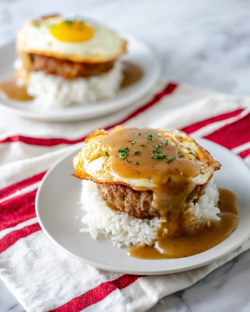 Two servings of a layered dish are shown on white plates set on a white marbled surface with a white cloth featuring red stripes nearby. Each plate contains a bottom layer of fluffy white rice shaped into a round mound. On top of the rice is a thick brown patty with a smooth, glossy light brown gravy draped over it, some gravy spilling onto the plate. The top layer is a fried egg with crispy golden edges and a lightly browned center, garnished with small green herbs. The background is softly blurred, focusing on the front serving. Photo taken with an iphone --ar 4:5 --v 7