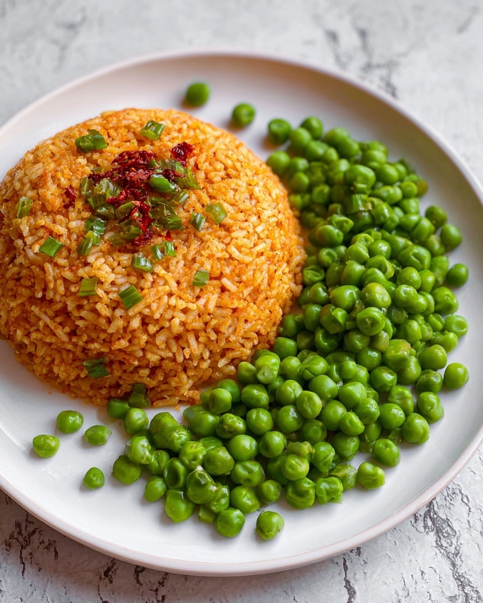The image shows a white plate with two food items. On the left side is a mound of orange-colored rice, shaped like a dome, with small green pieces and some red flakes on top. On the right side, there is a pile of fresh green peas, round and bright, spread loosely on the plate next to the rice. The plate rests on a white marbled surface. photo taken with an iphone --ar 4:5 --v 7