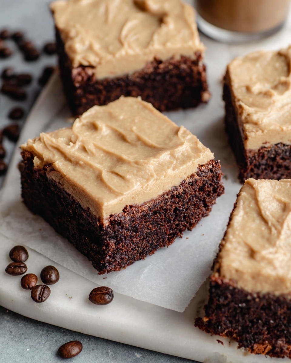 The image shows four square brownies with two layers, placed on a white marbled surface. The bottom layer is dark brown, dense, and slightly crumbly, while the top layer is a smooth, light tan frosting with visible creamy texture and spread marks. The brownies are arranged close together, with some coffee beans scattered around them for decoration. Part of the brownies is on a white plate, and a small part of a woman's hand can be seen holding the plate in the top left corner. Photo taken with an iphone --ar 4:5 --v 7