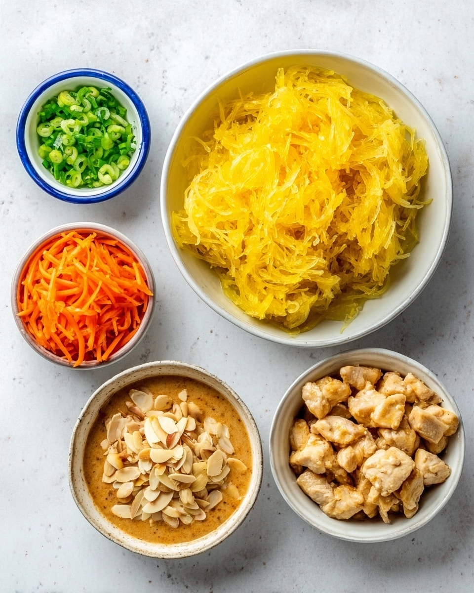 The image shows five small white bowls arranged on a white marbled surface. The top right bowl holds a large portion of bright yellow shredded cooked spaghetti squash with a soft texture. To the bottom right is a bowl filled with small cooked chunks of light brown chicken. Below to the left, there is a small bowl with a creamy brown-colored sauce. To the left of the squash, a bowl contains thin orange carrot sticks mixed with peeled almond slivers. At the top left, a tiny bowl holds chopped green onions. Photo taken with an iphone --ar 4:5 --v 7